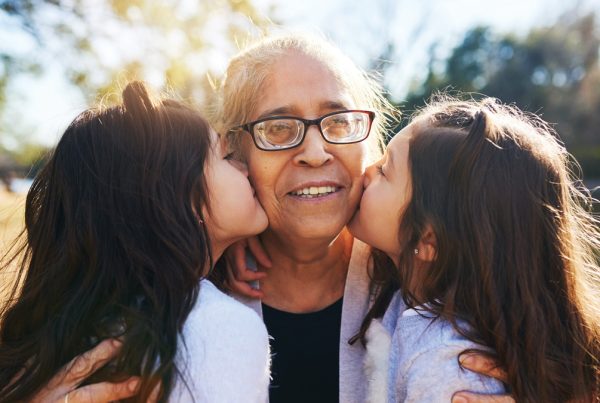 Grandmother receiving kisses from granddaughters | Caregiving and BoldAge PACE