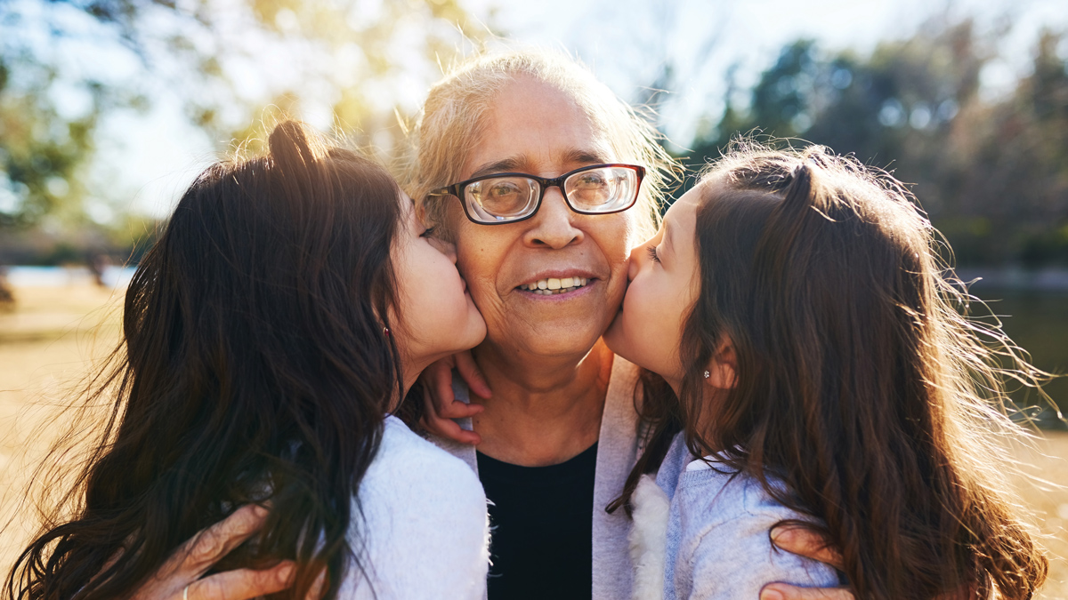 Grandmother receiving kisses from granddaughters | Caregiving and BoldAge PACE