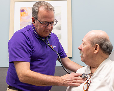 Physician checking patient's heart with stethoscope